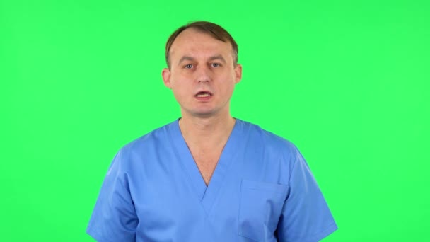 Medische man schreeuwt iemand bellen op een groen scherm in de studio. — Stockvideo