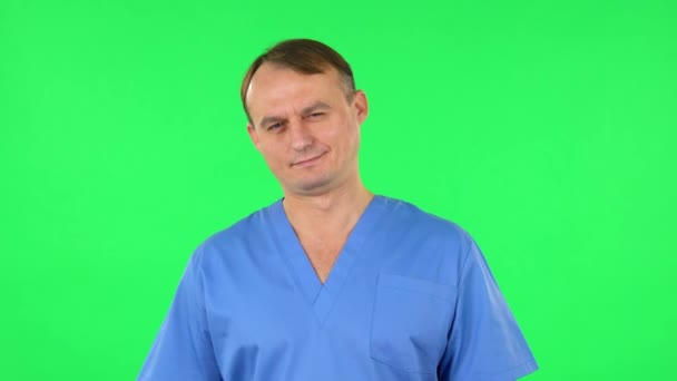 Medische man kijkt glimlachend naar de camera. Groen scherm — Stockvideo