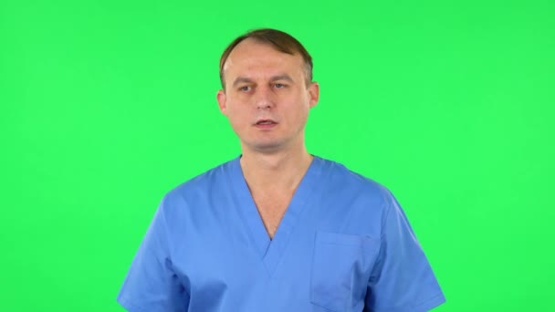 Medicul vorbind şi îndreptând mâna laterală spre ceva, copiază spaţiul. Ecran verde — Videoclip de stoc