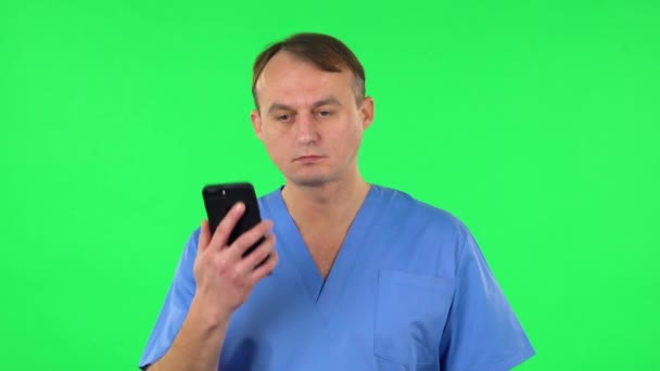 医療従事者が携帯電話で話してる緑の画面 — ストック動画