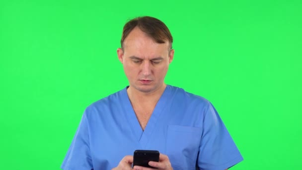 幸せな医者が電話でメールしてる緑の画面 — ストック動画