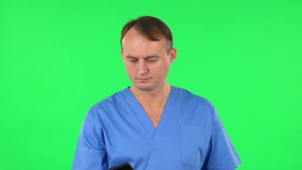 Medische man maakt selfie op mobiele telefoon dan op zoek naar foto 's op groen scherm. — Stockvideo