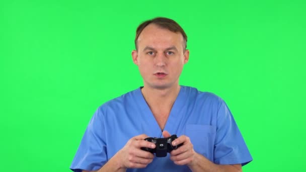 Médico jogando um jogo de vídeo usando um controle sem fio e perde. Tela verde — Vídeo de Stock