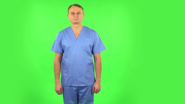 Medico in piedi, si diffonde in un sorriso e guarda la fotocamera. Schermo verde — Video Stock