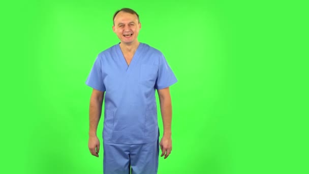Hombre médico rebosante de risa estar en positivo sobre la pantalla verde — Vídeos de Stock