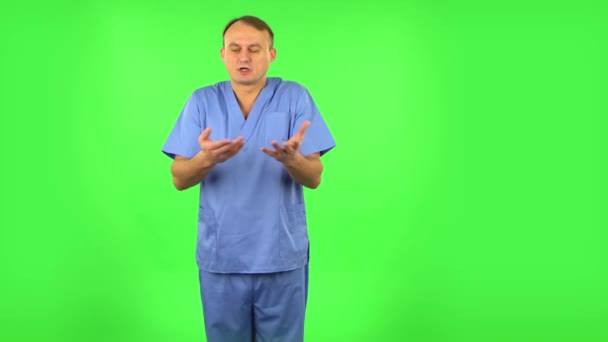 Medical man tells information by gesturing with his hands, gives recommendations. Green screen — 비디오