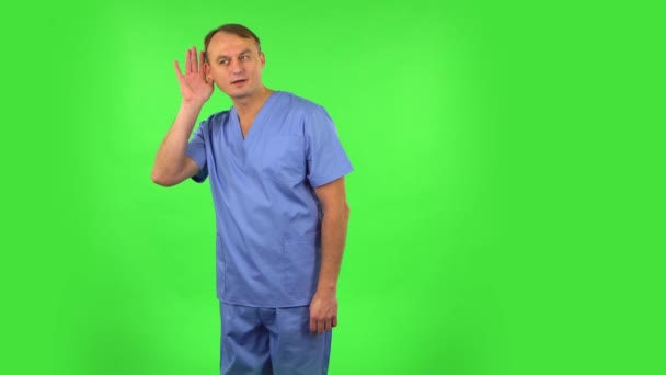Ιατρός που κρατιέται χέρι-χέρι προσπαθώντας να ακούσει ενδιαφέρουσες ειδήσεις που εκφράζουν την έννοια της επικοινωνίας. Πράσινη οθόνη — Αρχείο Βίντεο