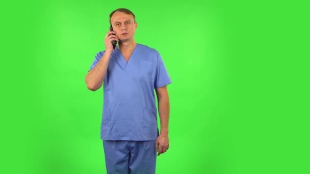 Medische man spreekt boos aan de telefoon, bewijst iets. Groen scherm — Stockvideo