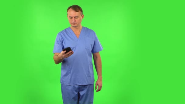 Medizinmann macht Selfie mit Handy und sieht dann Fotos auf grünem Bildschirm. — Stockvideo