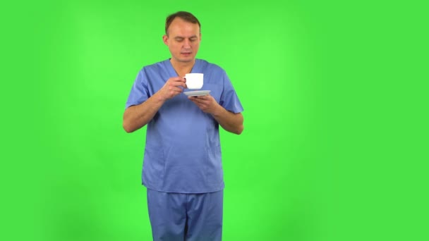 Medizinmann genießt Kaffee auf grünem Bildschirm. — Stockvideo