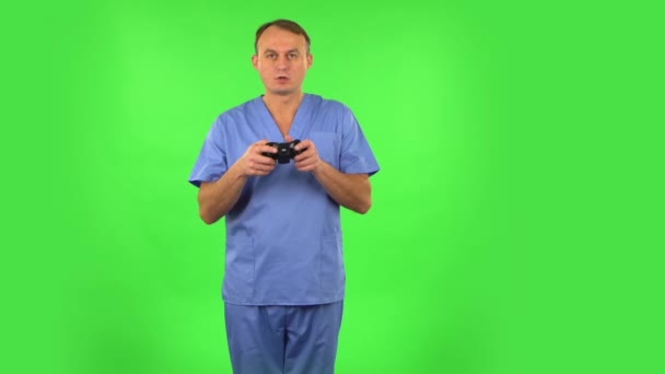 Médico jogando um jogo de vídeo usando um controle sem fio e perde. Tela verde — Vídeo de Stock