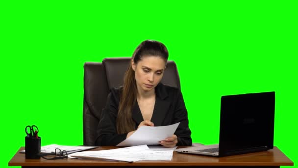Mulher estressada lê documento risca o que está escrito e joga papel amassado longe da mesa. Tela verde — Vídeo de Stock