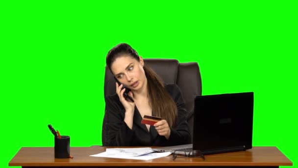 Business Woman at the workplace takes a credit card and call on the phone. Green screen. Studio — Stock Video