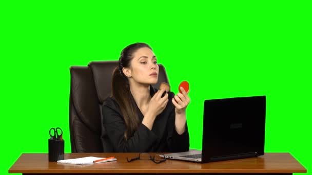 Geschäftsfrau am Arbeitsplatz schminkt sich und trägt Puder auf die Gesichtshaut auf, die in einen roten Spiegel schaut. Green Screen — Stockvideo