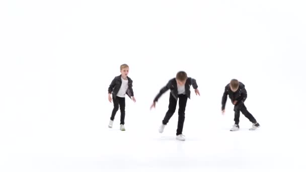 Kids are dancing a modern dance on the white background in black leather jackets and jeans — 비디오