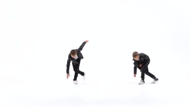 Los niños pequeños están bailando una danza moderna sobre el fondo blanco en chaquetas de cuero negro y jeans — Vídeo de stock