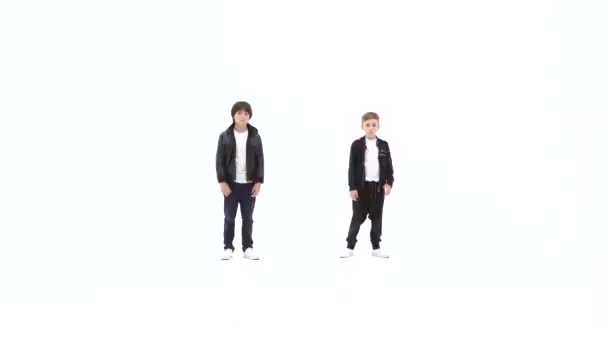 Små pojkar dansar en modern dans på den vita bakgrunden i svarta skinnjackor och jeans — Stockvideo