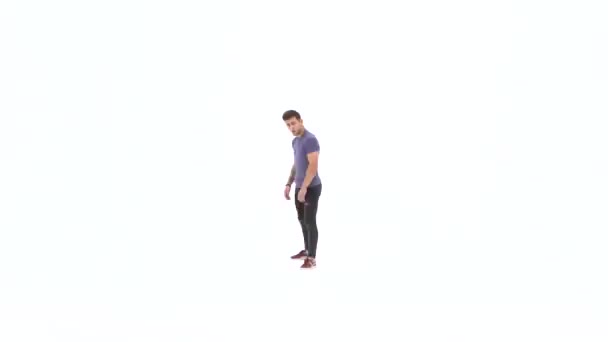 Мужчина танцует брейк-данс на белом фоне в простой серой футболке и серых джинсах — стоковое видео