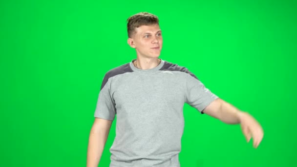 Mladý muž kráčí a pozdrav na zelené obrazovce, Chroma Key — Stock video