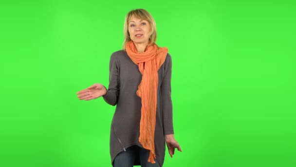 Midaldrende blondine kvinde taler om noget så gør en tys gestus, hemmelig. Grøn skærm – Stock-video