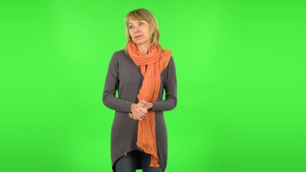 Middle aged blonde woman is surprised at what is happening around. Green screen — Stock Video