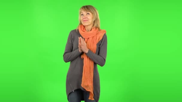 Middle aged blonde woman is daydreaming and smiling looking up. Green screen — Stock Video