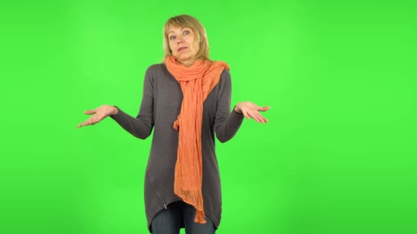 Een blonde vrouw van middelbare leeftijd praat verontwaardigd met iemand. Groen scherm — Stockvideo