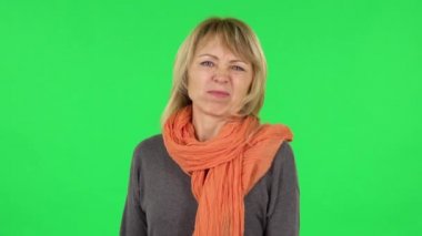 Orta yaşlı sarışın kadın portresi iğrenme gösteriyor. Yeşil Ekran