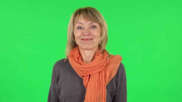 Portrait of middle aged blonde woman is smiling while looking at camera. Green screen — Stock Video