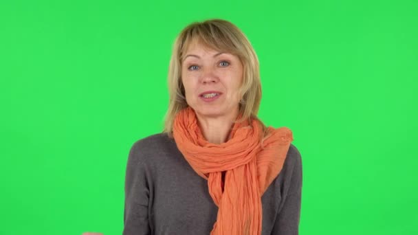 Orta yaşlı sarışın bir kadının portresi bir şey hakkında konuşuyor sonra da gizli bir jest yapıyor. Yeşil Ekran — Stok video