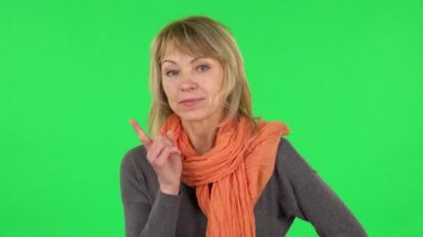 Orta yaşlı sarışın kadının portresi kızıyor, işaret parmağını sallıyor. Yeşil Ekran