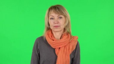 Orta yaşlı sarışın kadın portresi hayal kuruyor ve gülümsüyor. Yeşil Ekran