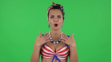 Portrait of beautiful frustrated girl in a swimsuit is saying oh my god and being shocked. Green screen