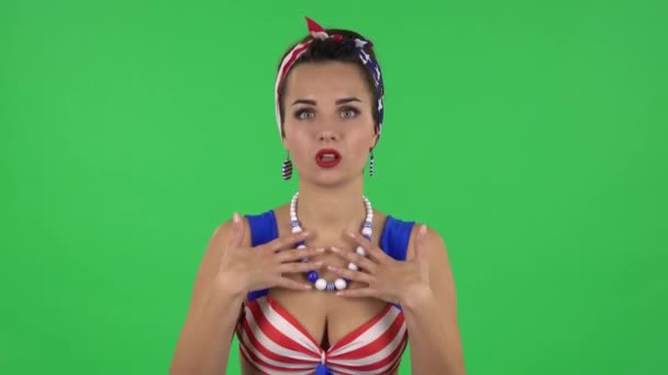 Portrait of beautiful girl in a swimsuit is talking about something then making a hush gesture, secret. Green screen — Stockvideo