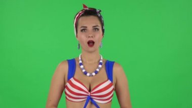 Portrait of beautiful girl in a swimsuit says wow, waves his head approvingly and shows thumb like sign. Green screen