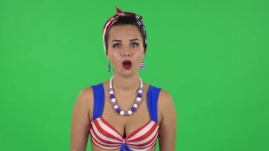 Portrait of beautiful girl in a swimsuit is very surprised and rejoicing saying wow. Green screen