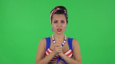 Portrait of beautiful girl in a swimsuit is looking at camera with anticipation, then very upset. Green screen