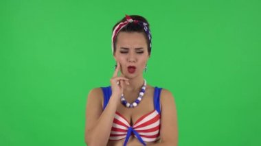 Portrait of beautiful girl in a swimsuit focused thinking about something, no idea. Green screen