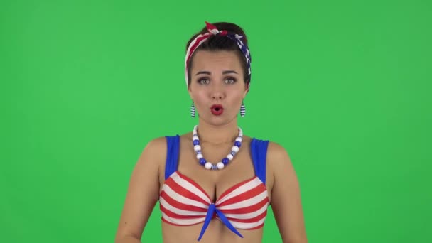 Portrait of beautiful girl in a swimsuit confused saying oops and shrugging. Green screen — Stockvideo