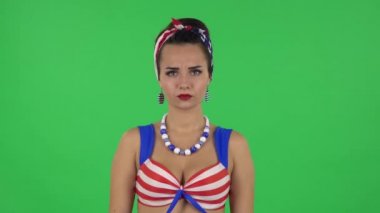 Portrait of beautiful girl in a swimsuit is threatening and shaking her index finger. Green screen