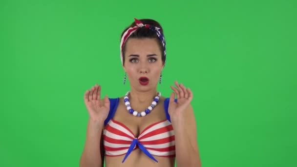 Portrait of beautiful girl in a swimsuit is frightened then sighs with relief and smiles. Green screen — Stok video