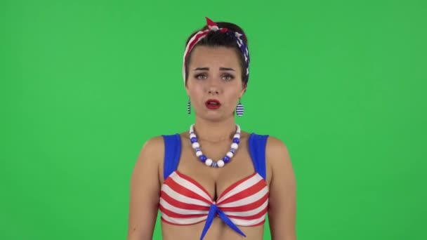 Portrait of beautiful upset girl in a swimsuit is shrugging. Green screen — 图库视频影像