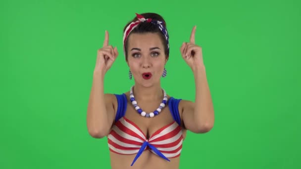 Portrait of beautiful girl in a swimsuit is pointing up fingers. Green screen — Stock Video