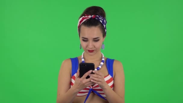 Portret van een mooi meisje in een badpak is praten voor mobiele telefoon en vreugde. Groen scherm — Stockvideo