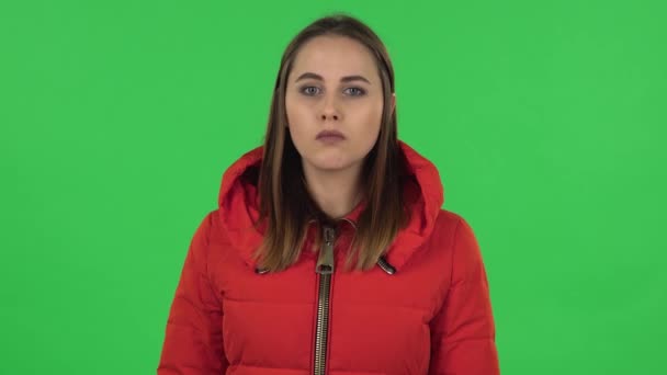 Retrato de una chica encantadora con una chaqueta roja frustrada y diciendo oh Dios mío, siendo sorprendido. Pantalla verde — Vídeo de stock