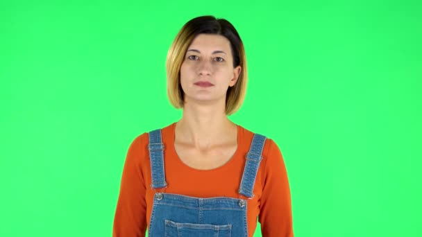 Mujer de pie y mira a la cámara. Pantalla verde — Vídeos de Stock