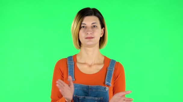 Girl claps her hands indifferently. Green screen — Stock video