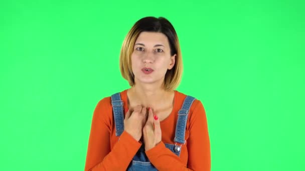 Girl talks about something then making a hush gesture, secret. Green screen — Stockvideo