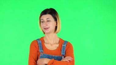 Young woman stands waiting with boredom. Green screen