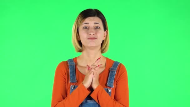 Girl looks with tenderness with folded arms in front of her. Green screen — Stockvideo